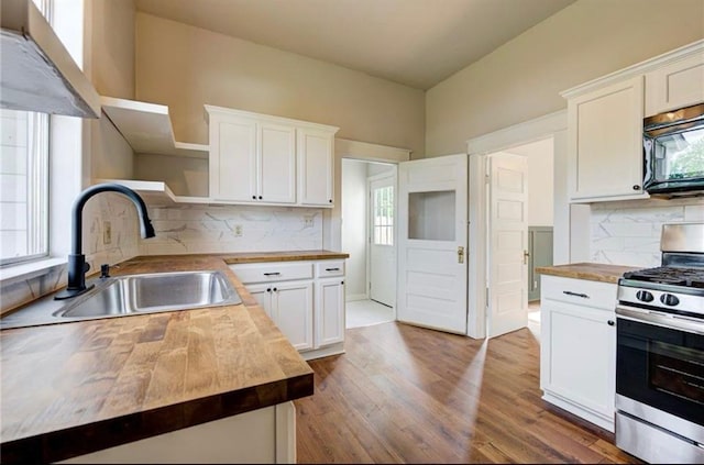312 S Ash St, Guthrie, OK 73044 - kitchen with wooden counters, open shelves, gas range, black microwave, and a sink