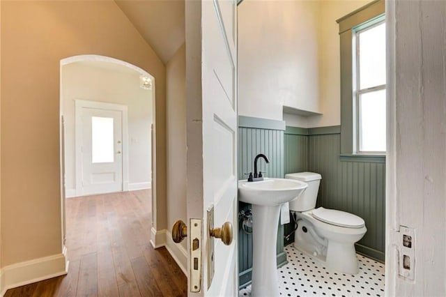 312 S Ash St, Guthrie, OK 73044 - bathroom featuring wainscoting, toilet, plenty of natural light, vaulted ceiling, and hardwood / wood-style floors