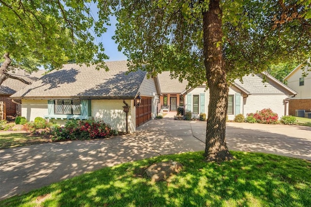 view of front of house with driveway, an attached garage, central AC unit, and brick siding