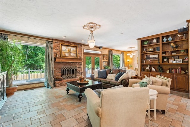 living area with stone tile floors, a fireplace, and a chandelier