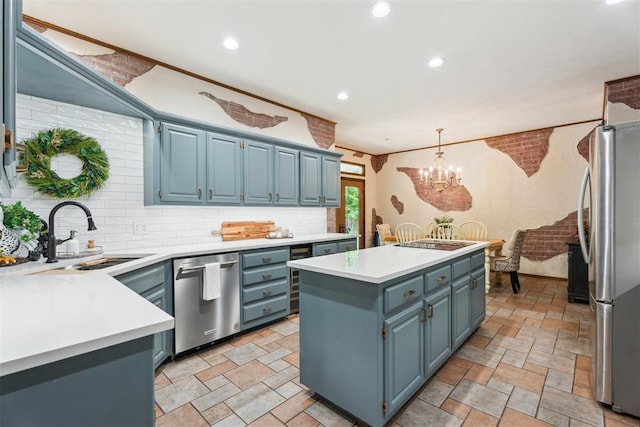 kitchen with stainless steel appliances, a sink, a kitchen island, stone tile flooring, and recessed lighting