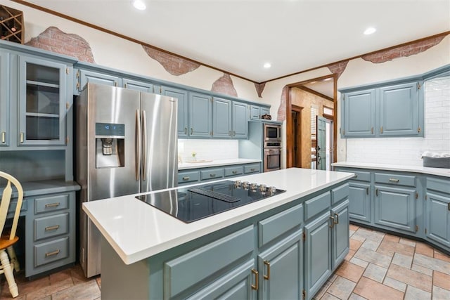 kitchen with appliances with stainless steel finishes, a kitchen island, decorative backsplash, light countertops, and recessed lighting