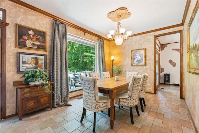 dining area featuring stone tile flooring, a chandelier, ornamental molding, and baseboards