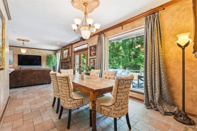 dining space with stone tile flooring, a chandelier, and ornamental molding