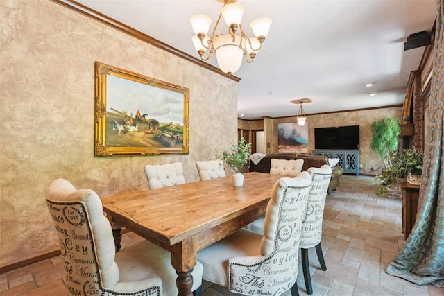 dining space featuring a chandelier, stone tile flooring, and a textured wall