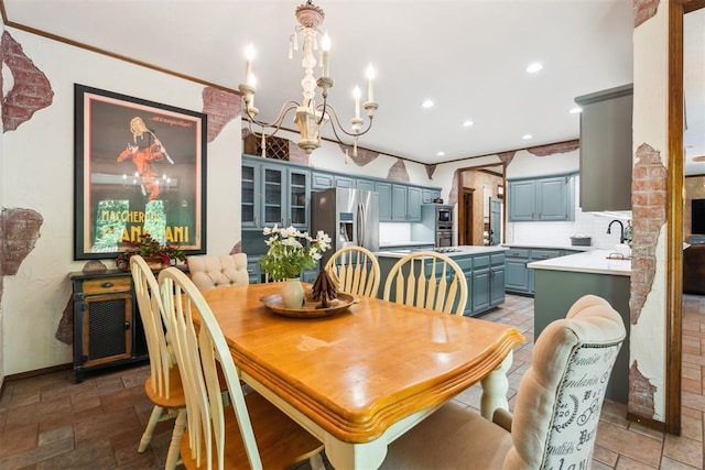 dining room with a chandelier, recessed lighting, baseboards, and stone tile flooring