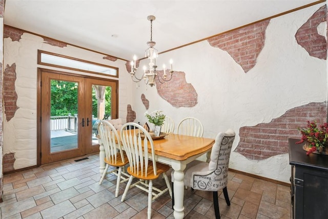 dining space with stone finish floors, a chandelier, french doors, and baseboards