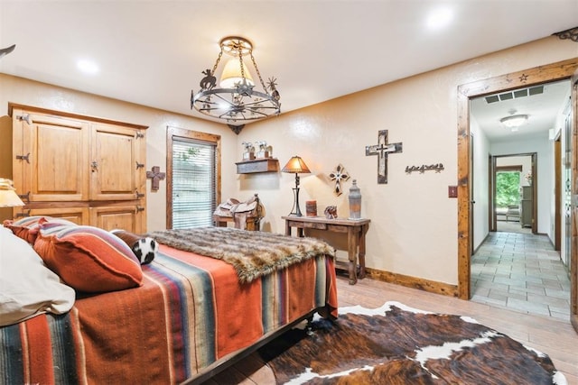 bedroom featuring light wood-type flooring, baseboards, and a chandelier