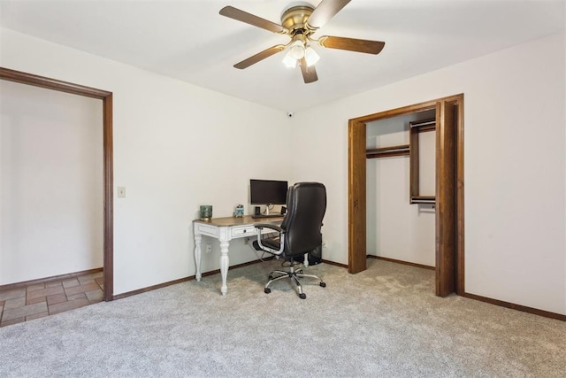 carpeted office featuring a ceiling fan and baseboards