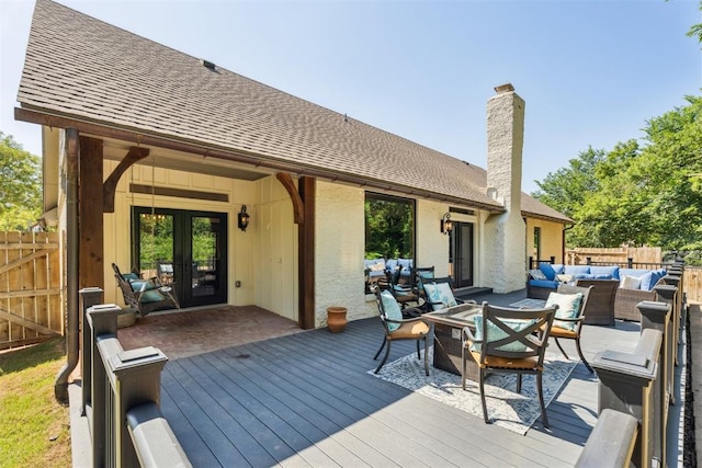 wooden terrace featuring an outdoor hangout area, french doors, and fence