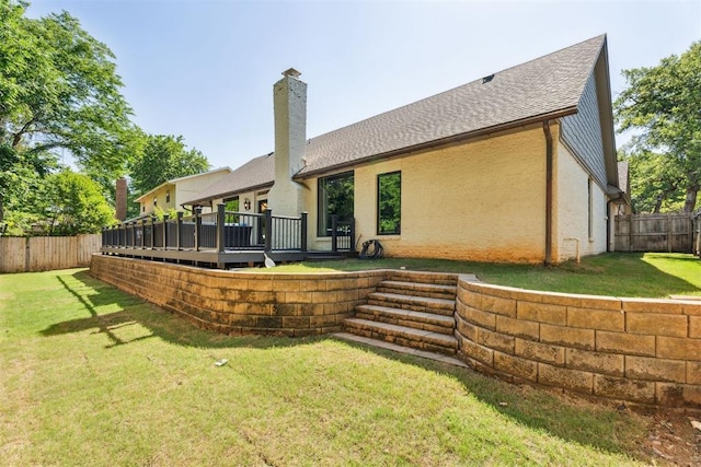 back of house with a wooden deck, a chimney, and a shingled roof