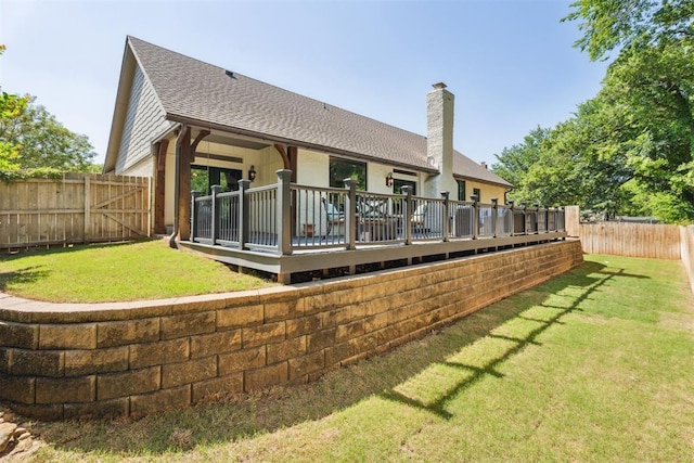 back of property featuring a wooden deck, a shingled roof, and a chimney