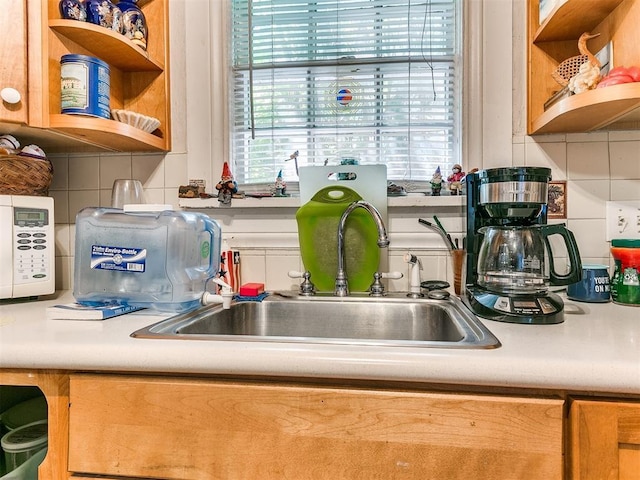 2321 Cashion Pl, Oklahoma City, OK 73112 - kitchen featuring open shelves, a sink, white microwave, and healthy amount of natural light