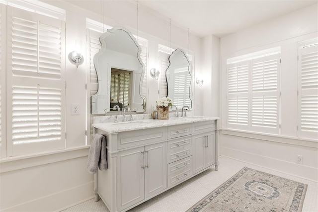 full bathroom featuring double vanity and baseboards
