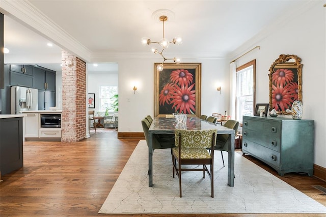 dining space featuring wood finished floors, a chandelier, ornamental molding, baseboards, and recessed lighting