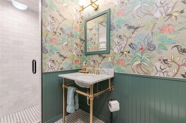 full bath featuring a wainscoted wall, wallpapered walls, and a stall shower