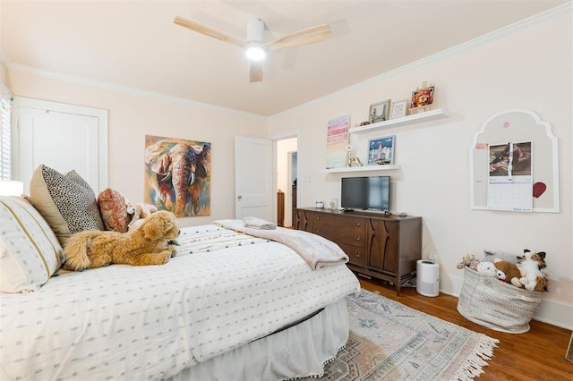 bedroom with wood finished floors, ornamental molding, a ceiling fan, and baseboards