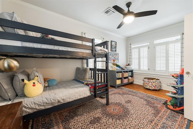 bedroom with wood finished floors and ornamental molding