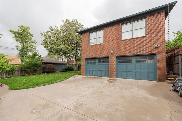 back of property with brick siding, a garage, and concrete driveway