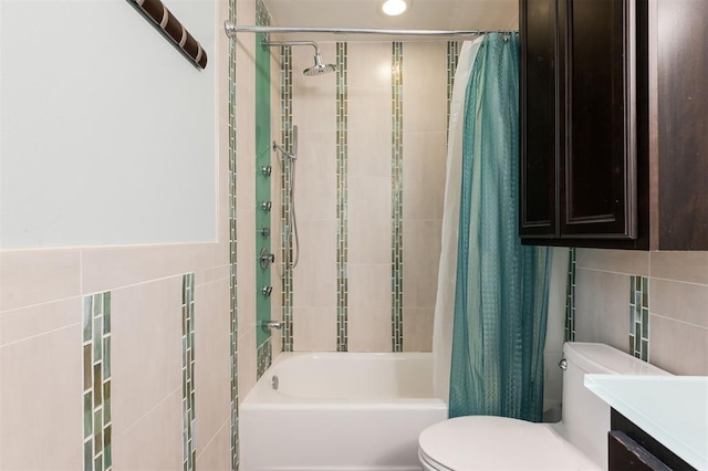 full bath featuring tile walls, toilet, shower / tub combo, and vanity
