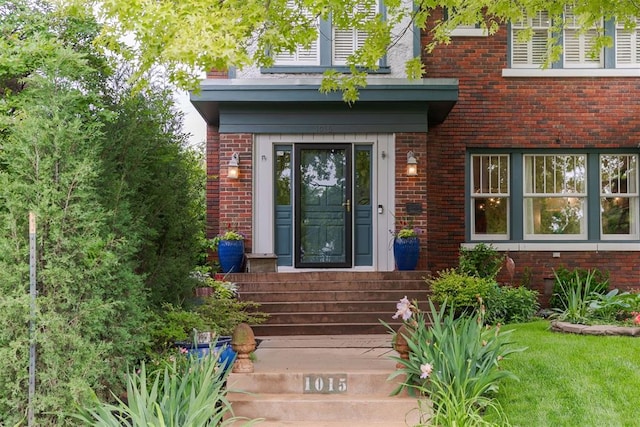 doorway to property featuring brick siding