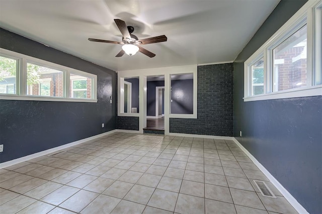 1706 E Oklahoma Ave, Guthrie, OK 73044 - empty room featuring healthy amount of natural light, ceiling fan, light tile patterned floors, and baseboards