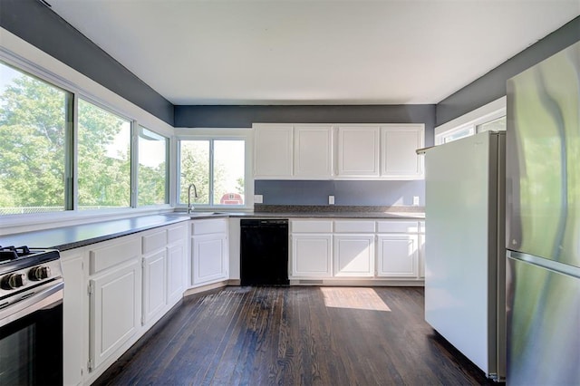 1706 E Oklahoma Ave, Guthrie, OK 73044 - kitchen featuring stainless steel appliances, a sink, dark wood finished floors, and white cabinetry