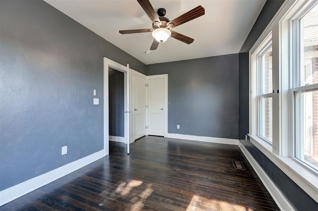 1706 E Oklahoma Ave, Guthrie, OK 73044 - spare room featuring plenty of natural light, baseboards, dark wood finished floors, and a ceiling fan