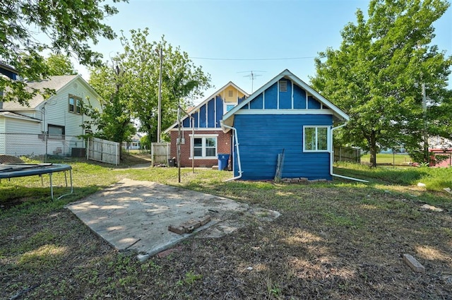 1706 E Oklahoma Ave, Guthrie, OK 73044 - back of property featuring a trampoline, brick siding, and board and batten siding
