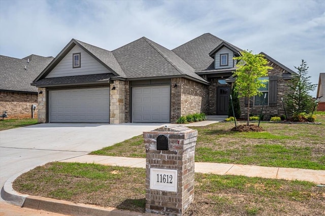 view of front facade with driveway, a garage, a shingled roof, brick siding, and a front yard
