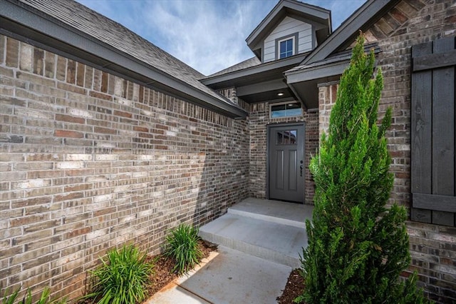 doorway to property featuring brick siding