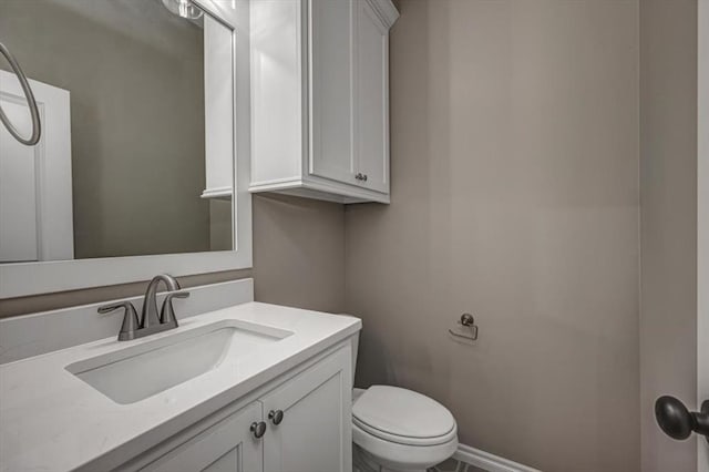 half bath featuring vanity and toilet