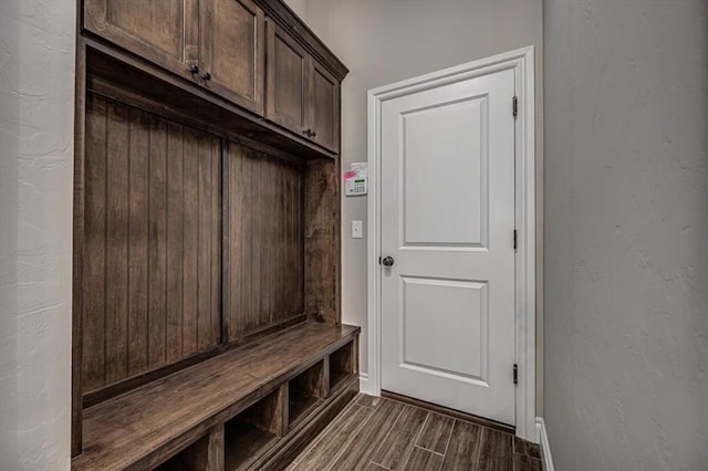 mudroom with baseboards and dark wood-type flooring