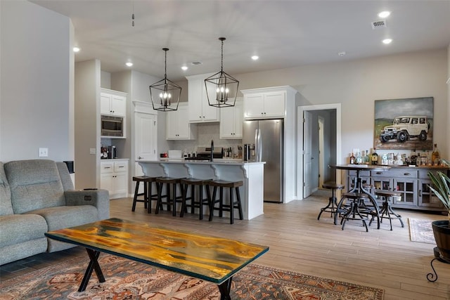 living area featuring light wood-style floors, recessed lighting, and a chandelier