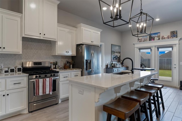 kitchen with appliances with stainless steel finishes, a sink, decorative backsplash, white cabinets, and recessed lighting