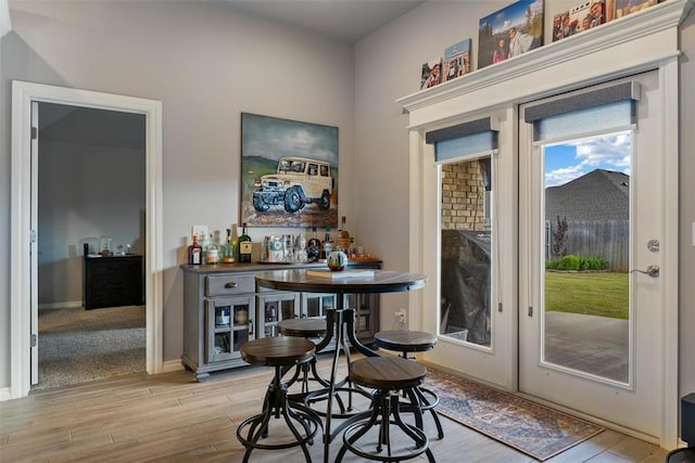 indoor dry bar featuring light wood finished floors and baseboards
