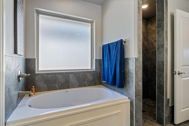 bathroom with a walk in shower and a bath