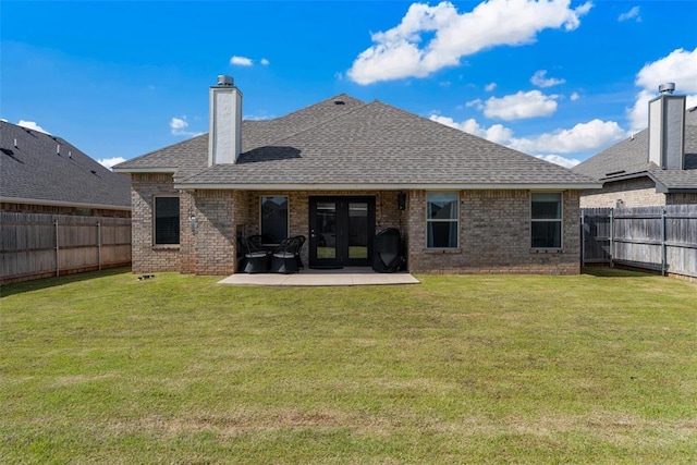 rear view of house featuring brick siding, a patio area, a shingled roof, and a chimney
