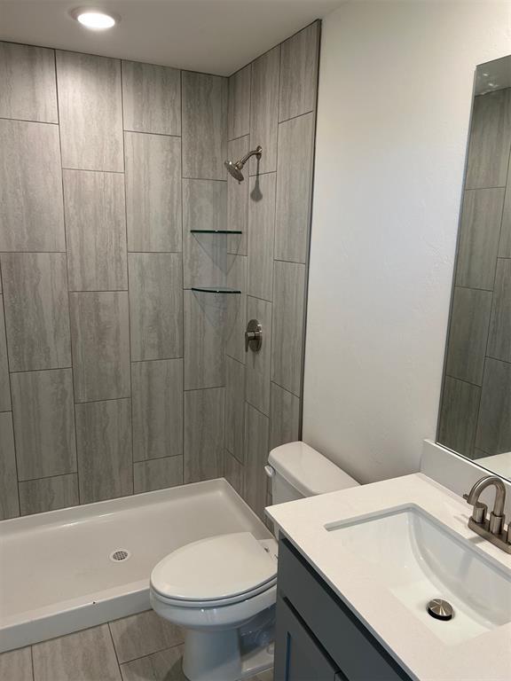 2933 NW 196th Pl, Edmond, OK 73012 - full bathroom featuring toilet, a tile shower, and vanity