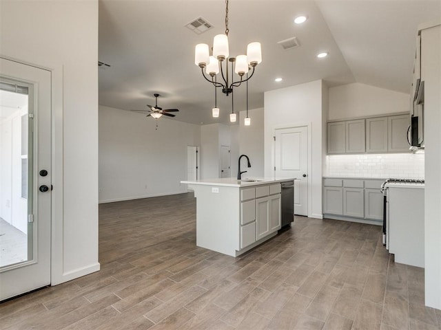 959 SE 16th Ter, Newcastle, OK 73065 - kitchen with stainless steel dishwasher, a sink, a ceiling fan, backsplash, and light wood-style flooring