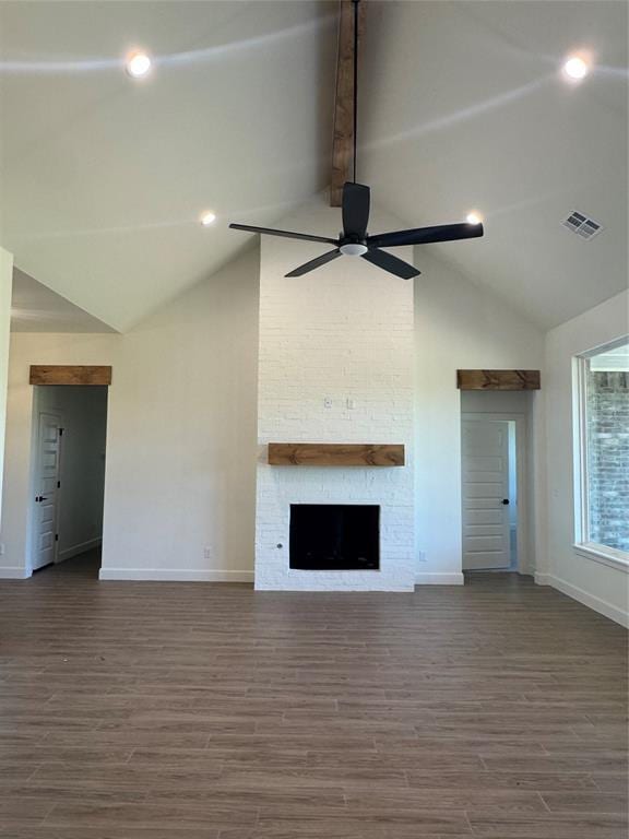 9596 Regado Ct, Guthrie, OK 73044 - unfurnished living room with baseboards, ceiling fan, high vaulted ceiling, a stone fireplace, and dark wood-style floors
