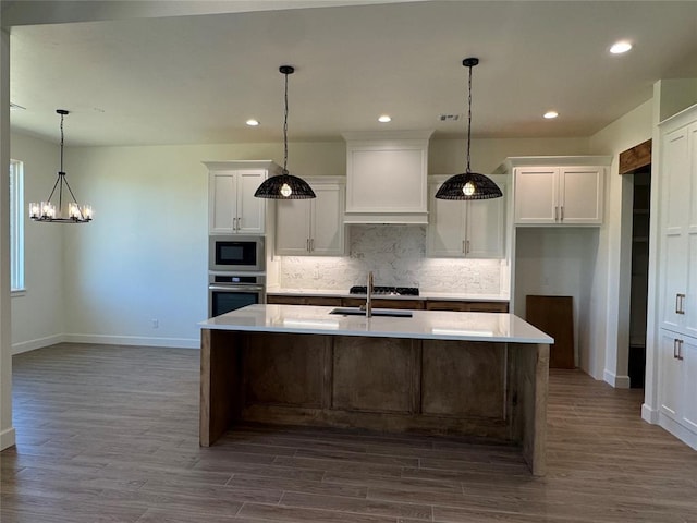 9596 Regado Ct, Guthrie, OK 73044 - kitchen featuring appliances with stainless steel finishes, baseboards, a chandelier, tasteful backsplash, and dark wood-style floors