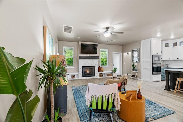 2803 Redwood Ct, Newcastle, OK 73065 - living area with a glass covered fireplace, ceiling fan, and light wood-type flooring