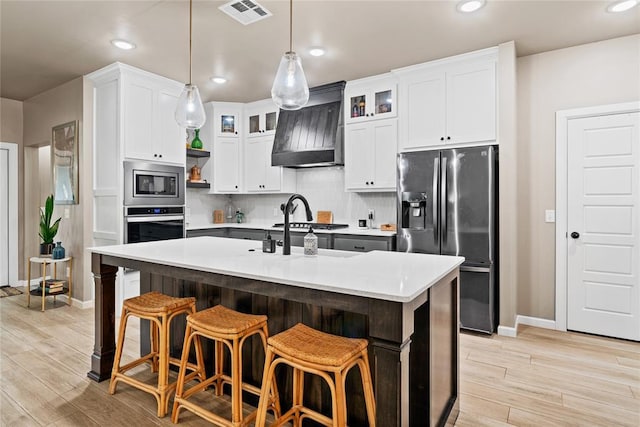 2803 Redwood Ct, Newcastle, OK 73065 - kitchen featuring appliances with stainless steel finishes, custom exhaust hood, baseboards, light countertops, and light wood-style flooring