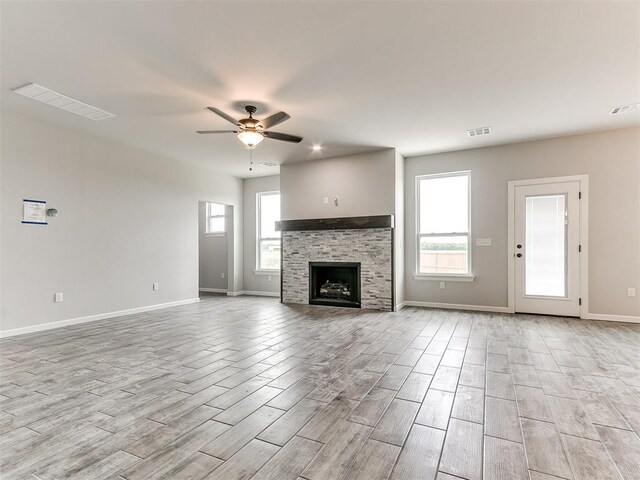 929 SE 16th Ter, Newcastle, OK 73065 - unfurnished living room featuring light wood-type flooring, a ceiling fan, baseboards, and a stone fireplace