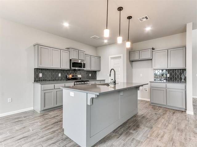 929 SE 16th Ter, Newcastle, OK 73065 - kitchen with stainless steel appliances, gray cabinetry, a sink, and backsplash