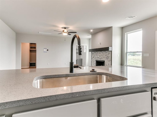 929 SE 16th Ter, Newcastle, OK 73065 - kitchen featuring a sink, light stone countertops, a fireplace, dishwashing machine, and open floor plan
