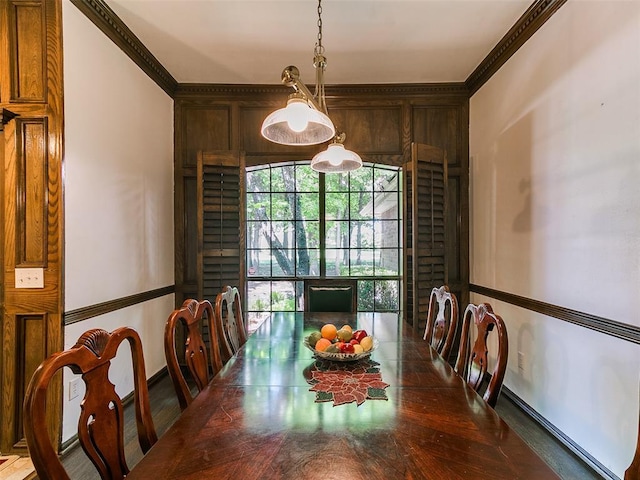 dining room featuring crown molding and baseboards