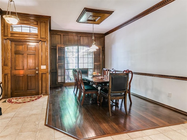 dining area featuring light tile patterned flooring, ornamental molding, and baseboards