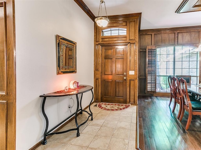 entrance foyer featuring ornamental molding and baseboards